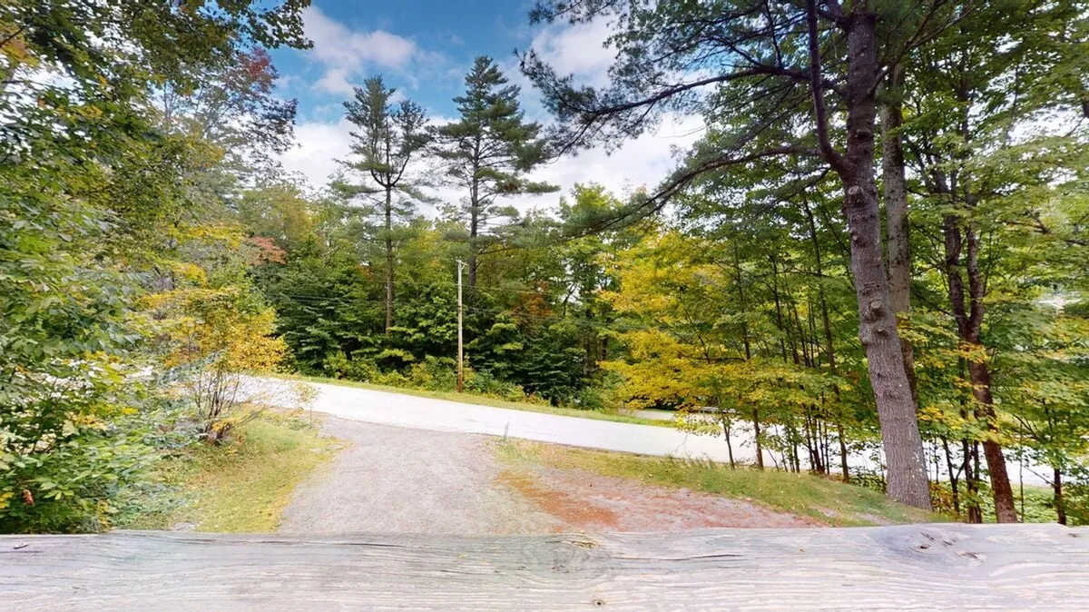 A serene view of a gravel path bordered by trees and a curving road, inviting exploration. The image suggests the ease of accessing outdoor activities like walking or biking, and hints at the seasonal changes guests can enjoy.